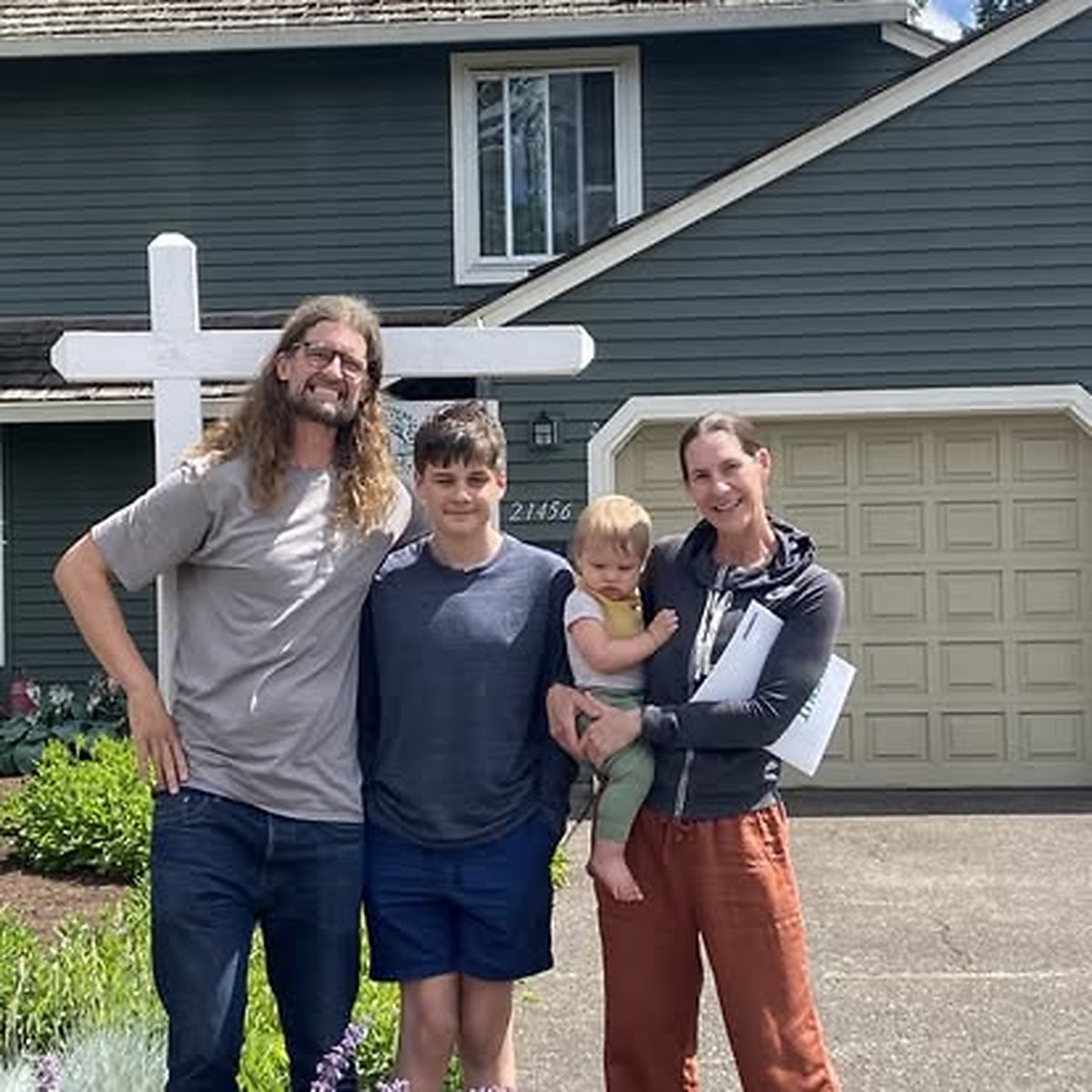 A family of four on closing day outside their new Portland home.
